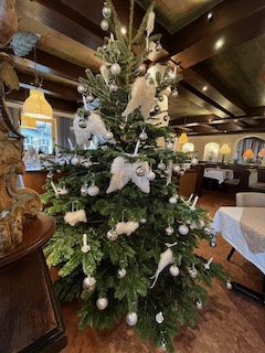 Ein Tannenbaum, der mit verschieden großen Engelsflügeln und glänzenden und matten Silberkugeln geschmückt ist