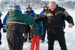 Ein gefangener Fisch wird vom Haken genommen. Auf ihn wartet die Pfanne.